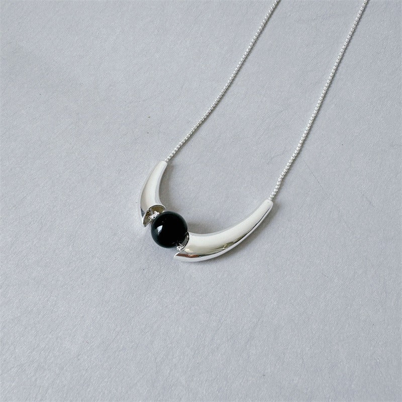 Necklace: round black agate bead held in a polished curved arc, second view