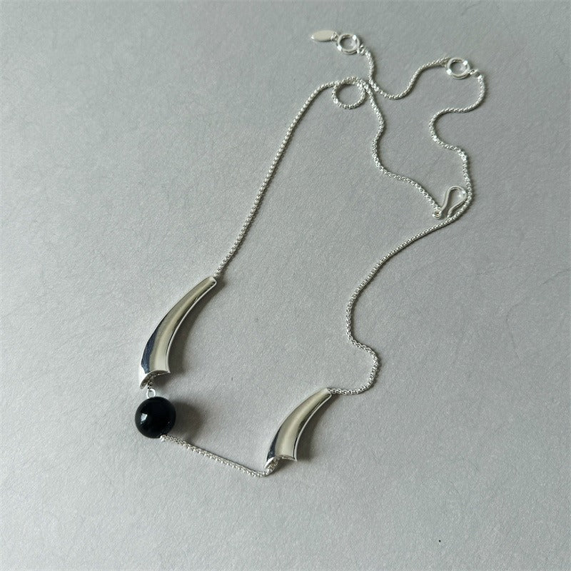 Necklace: round black agate bead held in a polished curved arc, third view