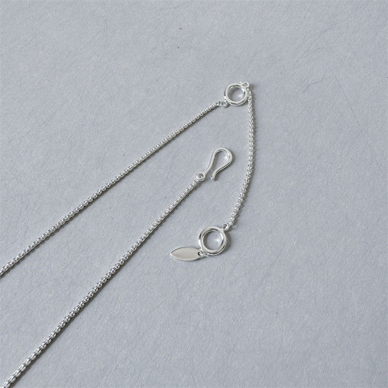 Necklace: round black agate bead held in a polished curved arc, fourth view
