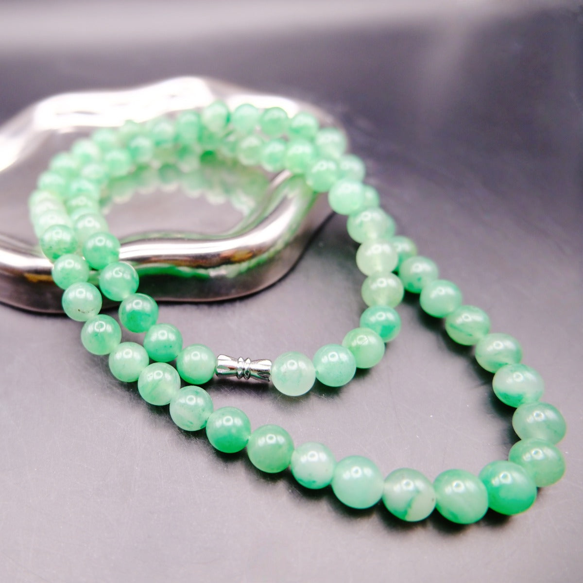 Necklace: strand of round green African Jade beads with a silver-coloured barrel clasp