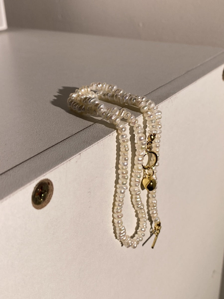 Necklace: strand of small ivory freshwater rice pearls, 3-4mm, fourth view