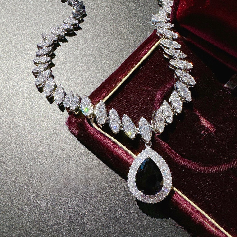 Necklace: royal blue pear-cut stone in a halo pendant on a marquise-stone chain, second view