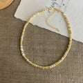 Necklace: white mother-of-pearl and gold-coloured disc beads with an extender chain
