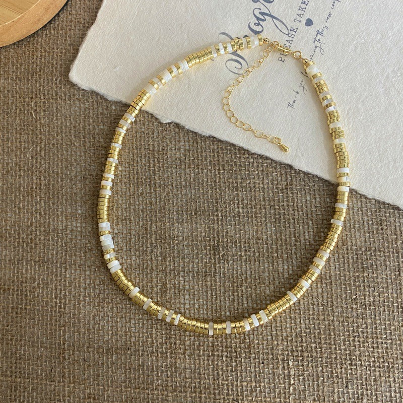 Necklace: white mother-of-pearl and gold-coloured disc beads with an extender chain