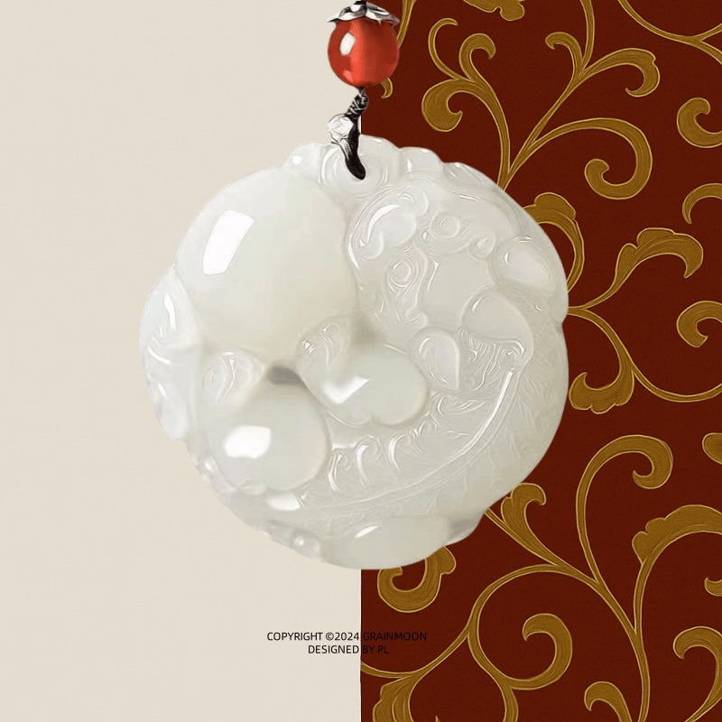 Pendant: white Hetian jade round medallion carved with a Pixiu, topped with a red bead