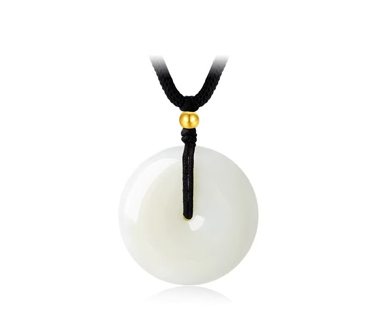 Pendant: white round Hetian jade disc with a gold bead on a black cord, second view