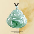 Pendant: pale icy green jadeite carved as a laughing Buddha on a black cord