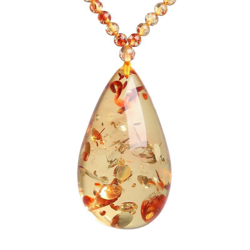 Pendant necklace: pale yellow floral amber teardrop with red-orange flake inclusions, second view