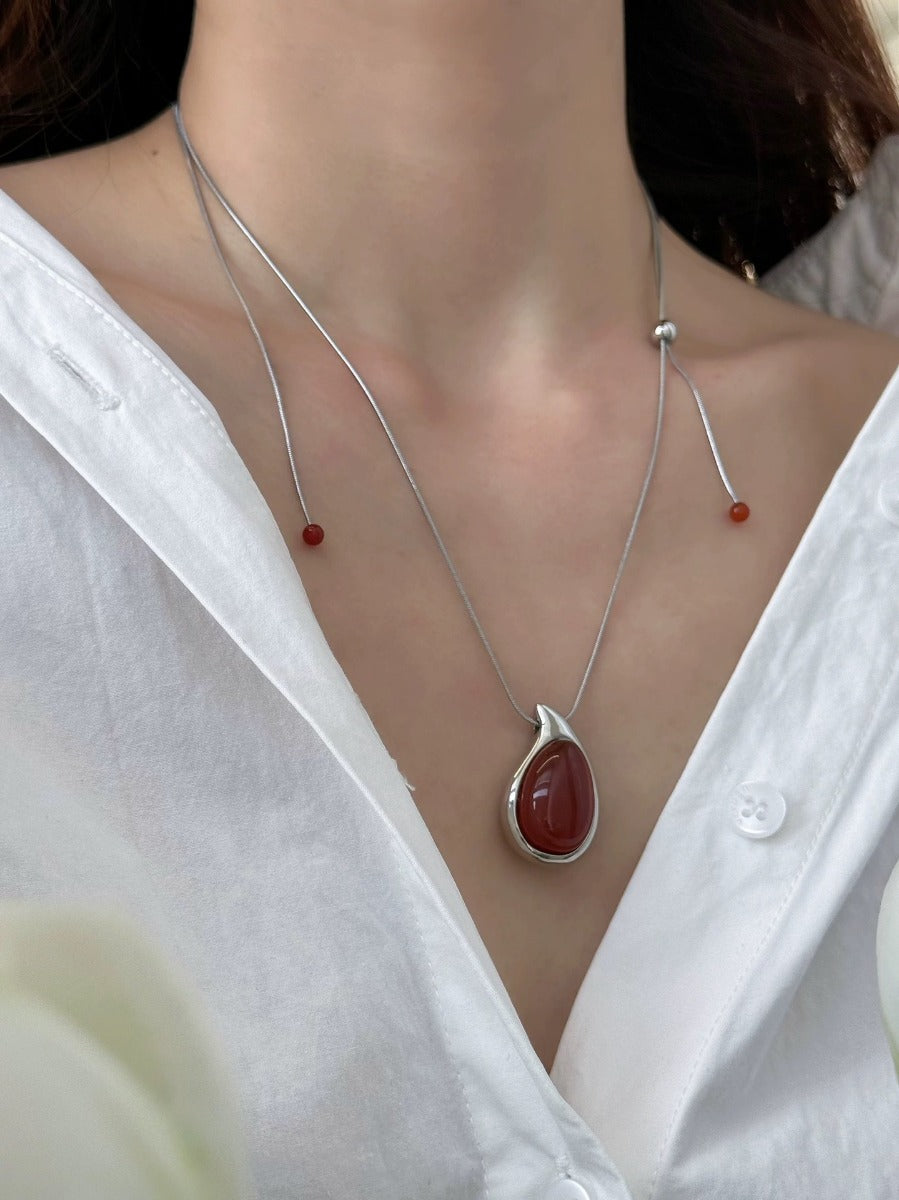 Pendant necklace: deep red carnelian teardrop in a silver-tone frame, second view