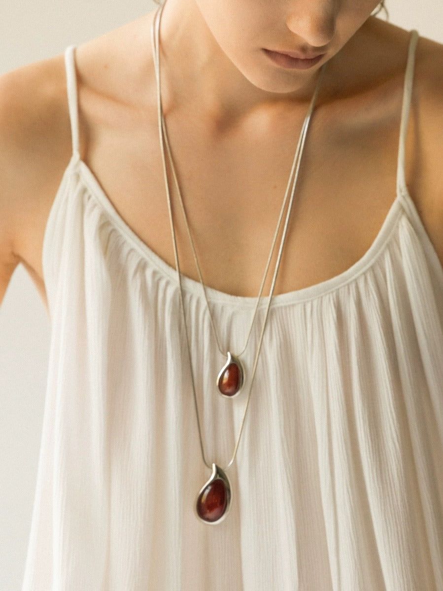 Pendant necklace: deep red carnelian teardrop in a silver-tone frame, fourth view