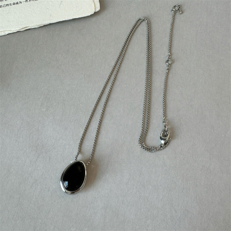 Pendant necklace: black agate teardrop in a silver-tone frame on a silver-tone chain