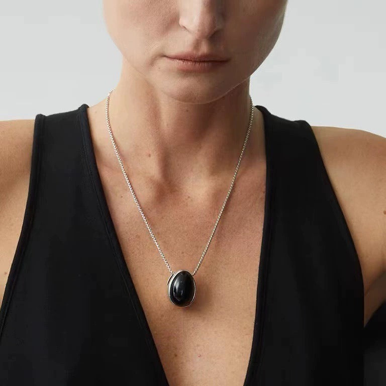 Pendant necklace: black agate teardrop in a silver-tone frame on a chain, second view