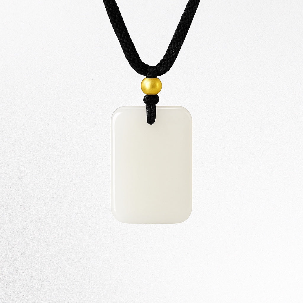 Pendant: white rectangular Hetian jade plaque with a gold bead on a black cord, third view